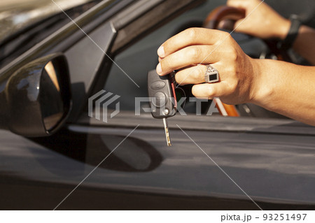 Car key in a man's hand with car. Car key in a man's hand with car. 93251497