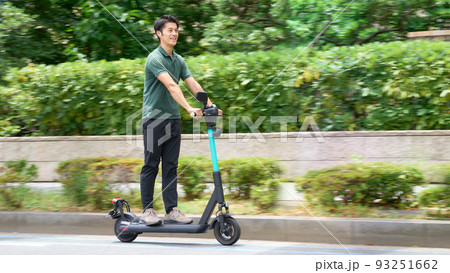 電動キックボードで街を走行する若い男性 電動キックボードで街を走行する若い男性 93251662