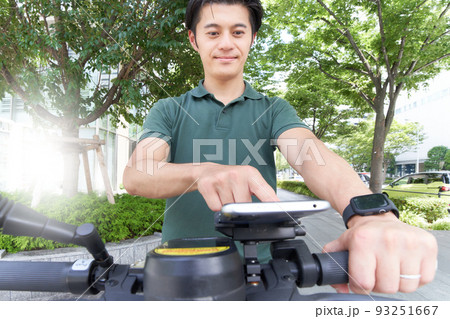 キックボード/自転車に装着したスマホを操作する若い男性 キックボード/自転車に装着したスマホを操作する若い男性 93251667