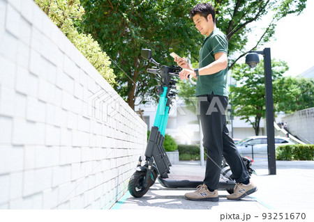 電動キックボードのポートにてスマホの画面を見る若い男性 電動キックボードのポートにてスマホの画面を見る若い男性 93251670