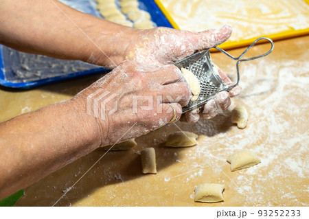 Old woman hands preparing fresh italian pasta gnocchi. Concept Italian Traditional cuisine Old woman hands preparing fresh italian pasta gnocchi. Concept Italian Traditional cuisine 93252233