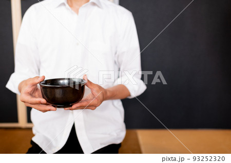 抹茶用のお茶碗を両手で持つ男性 93252320