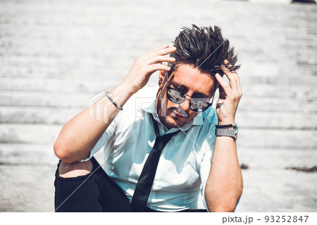 Depressed unsuccessful businessman feels terrible headache, hands shocked by bankruptcy stock downfall sitting on stone stairs. Stressed tired man feels despair lost money online or got problem debt. 93252847