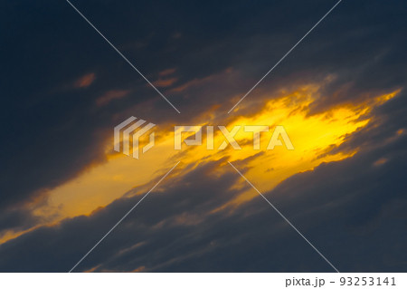 Light spot orange sunset through dark rain clouds storm beam light sky weather background Light spot orange sunset through dark rain clouds storm beam light sky weather background 93253141