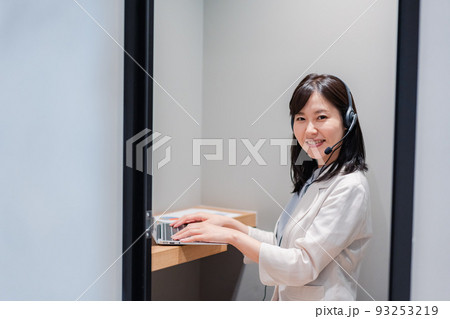 シェアオフィスの個室ブースでリモート会議をする女性 シェアオフィスの個室ブースでリモート会議をする女性 93253219
