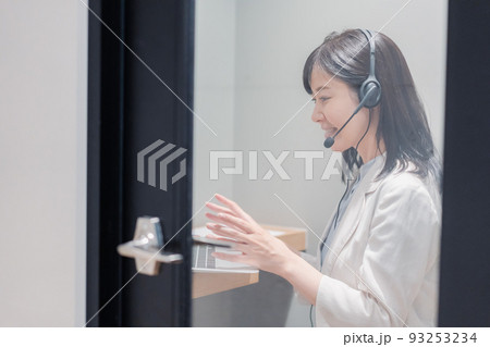 シェアオフィスの個室ブースでリモート会議をする女性 シェアオフィスの個室ブースでリモート会議をする女性 93253234
