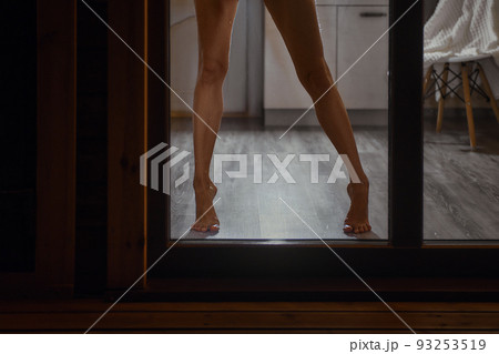 Barefoot female legs on the floor in front of the window Barefoot female legs on the floor in front of the window 93253519