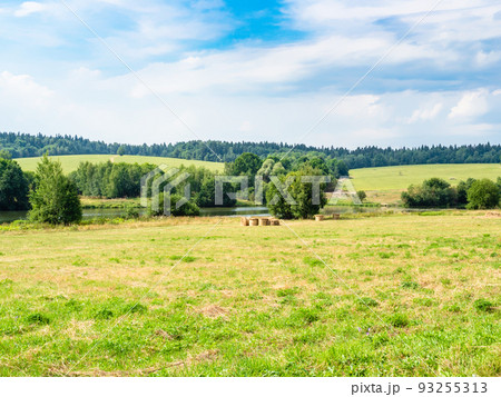 mowed meadow next to small river and green hills mowed meadow next to small river and green hills 93255313