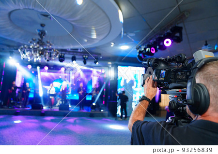 videographer with broadcast video camera to show on large screens.  93256839