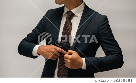 拳銃を構えるスーツの人物 93259291