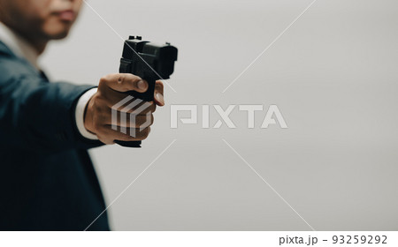 拳銃を構えるスーツの人物 93259292