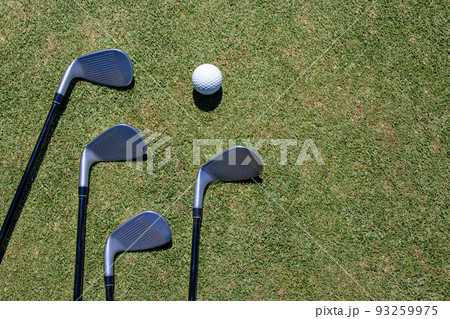 Golf club and golf ball on green grass Golf club and golf ball on green grass 93259975