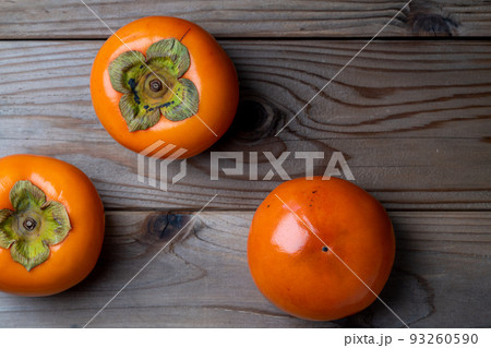 木の板の上においた柿の写真 93260590