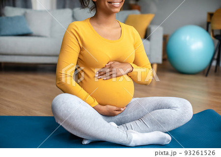 Body care and workout. Smiling young pregnant black lady touch big belly, feels movement of baby Body care and workout. Smiling young pregnant black lady touch big belly, feels movement of baby 93261526