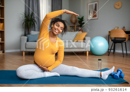 Motherhood and workout. Glad pretty millennial pregnant african american lady practicing yoga Motherhood and workout. Glad pretty millennial pregnant african american lady practicing yoga 93261614