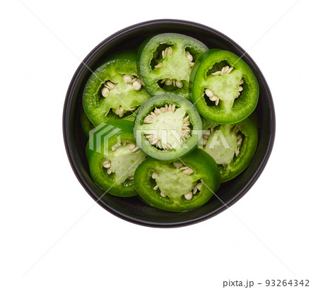 Fresh green cut chili pepper pieces in a black ceramic bowl isolated on white background, top view. Fresh green cut chili pepper pieces in a black ceramic bowl isolated on white background, top view. 93264342