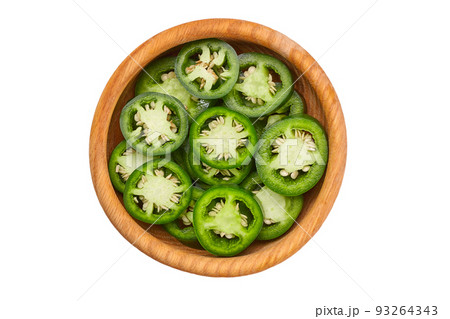 Fresh green cut chili pepper pieces in a wooden bowl isolated on white background top view. Fresh green cut chili pepper pieces in a wooden bowl isolated on white background top view. 93264343