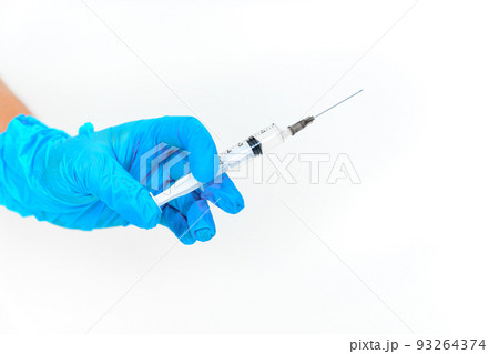 women's hands in blue gloves with a disposable syringe.  93264374
