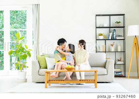 リビングで仲良しの若い家族 93267460