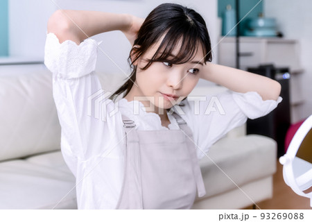 髪をまとめる若い女性 髪をまとめる若い女性 93269088