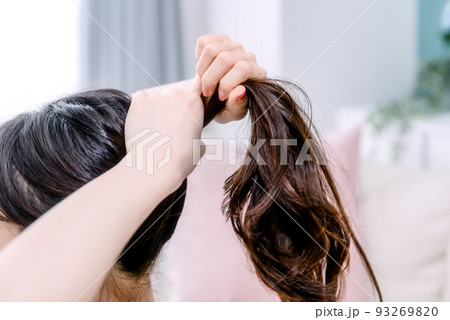 髪をまとめる若い女性 93269820