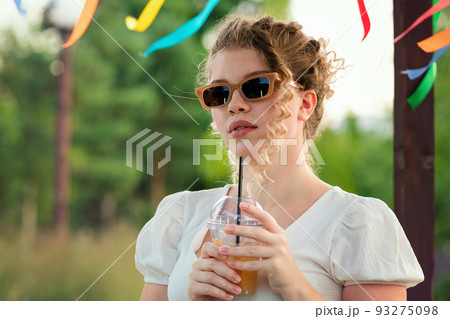 Girl with drink outdoors 93275098