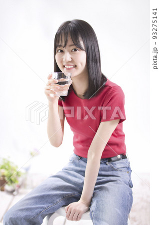 水の入ったグラスを持つ笑顔の若い女性 水の入ったグラスを持つ笑顔の若い女性 93275141