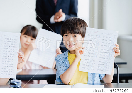 塾のテスト用紙を見せる小学生 93275260