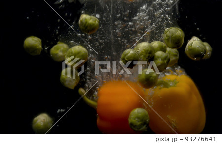 Brussels sprouts and paprika falling into the water with a splash and bubbles Brussels sprouts and paprika falling into the water with a splash and bubbles 93276641