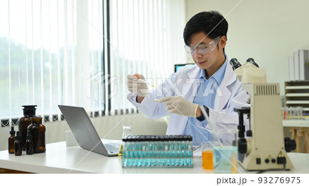 Male research scientist is conducting experiment in laboratory. Medicine and science research concepts 93276975