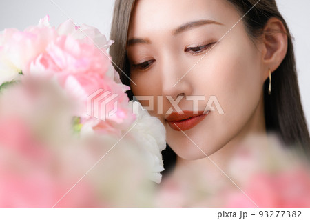 ピンクの花（ラナンキュラス）と美しい日本人女性 93277382
