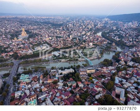 Drone view of old city located near hills and river on summer day in Tbilisi, Georgia 93277870
