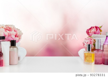 Towels with flowers on light table against blurred background 93278331
