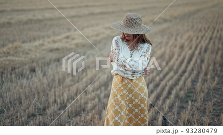 Ukrainian woman in traditional ethnic costume and straw hat in wheat field. Attractive stylish lady 93280479