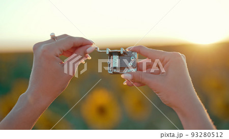 Female hands rotating gears of old music box mechanism. Lady turning the lever of retro small Female hands rotating gears of old music box mechanism. Lady turning the lever of retro small 93280512