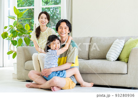 リビングで寛ぐ若い家族 93280936