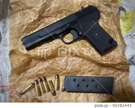 油紙に包まれた怪しい雰囲気の拳銃 93282445
