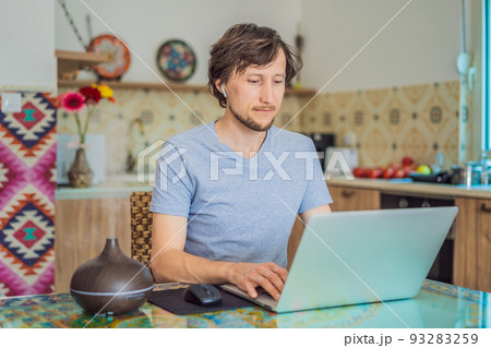 Essential oil diffuser on the table steaming while man using laptop Essential oil diffuser on the table steaming while man using laptop 93283259