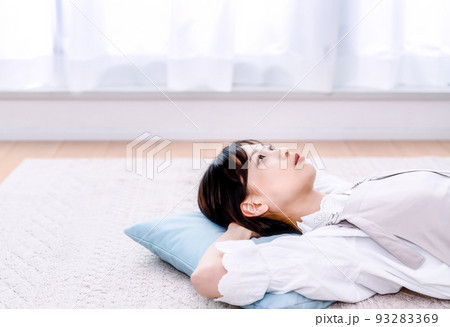 部屋で仰向けになって休憩する若い女性 部屋で仰向けになって休憩する若い女性 93283369