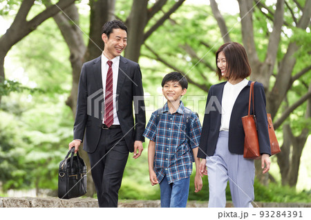 笑顔を見せながら歩く3人家族 笑顔を見せながら歩く3人家族 93284391