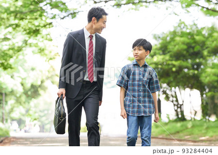 話しながら歩くと男子小学生と父親 話しながら歩くと男子小学生と父親 93284404