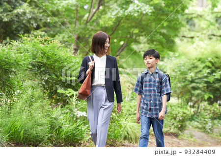 話しながら歩くと男子小学生と母親 話しながら歩くと男子小学生と母親 93284409