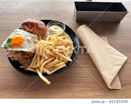目玉焼きが乗ったハンバーガーとポテトフライとバーガー袋 93285046