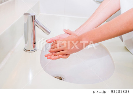 A man is washing his hands in the bathroom for cleanliness., Hand washing for cleanliness and away from germs A man is washing his hands in the bathroom for cleanliness., Hand washing for cleanliness and away from germs 93285383