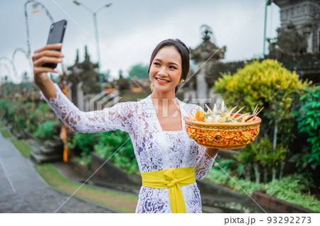 attractive balinese young woman taking her selfie photo 93292273