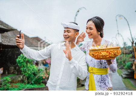 balines couple make a video call during holy day of galungan 93292418