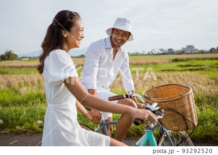happy couple cycling on the road in countryside happy couple cycling on the road in countryside 93292520