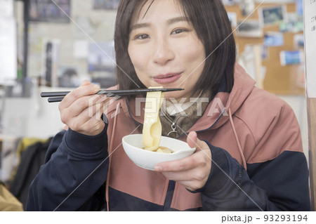 山小屋でなべ焼きを食べる若い女性 93293194