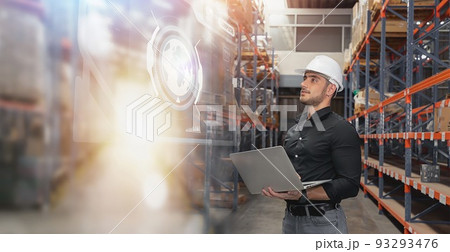Professional Man Worker wearing hard hat checks stock and inventory with Laptop Computer in the retail of shelves with goods. 93293476
