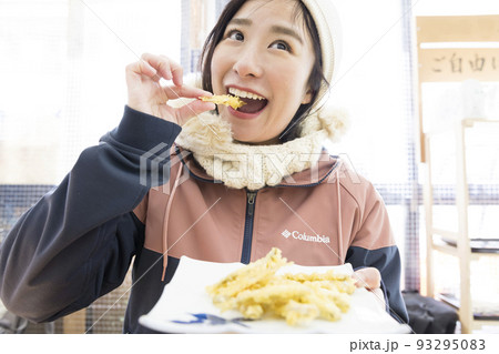 揚げたてのわかさぎのフライを食べる若い女性 揚げたてのわかさぎのフライを食べる若い女性 93295083
